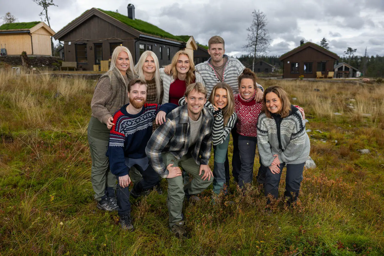 Deltakerne i TV 2-serien Fjellhytta foran hyttene fra Familiehytta på Budor